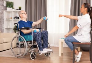 man in wheelchair using dumbbell